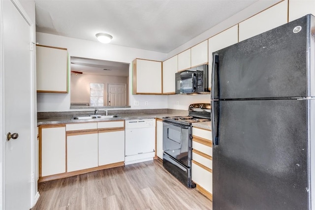 kitchen with black appliances, light wood-style flooring, white cabinetry, and a sink