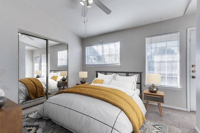 bedroom featuring lofted ceiling, multiple windows, carpet, and a closet