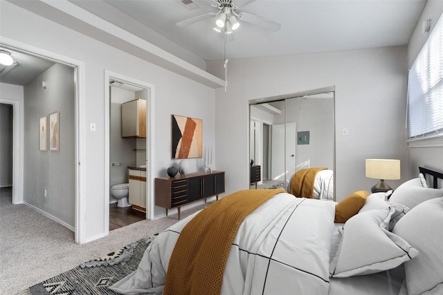 carpeted bedroom with a ceiling fan, baseboards, vaulted ceiling, a closet, and ensuite bath