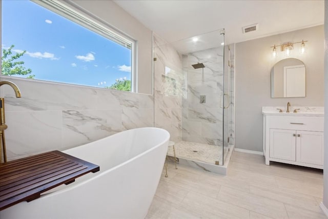 bathroom with vanity, tile walls, and independent shower and bath