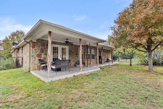 back of house featuring a lawn, ceiling fan, and a patio