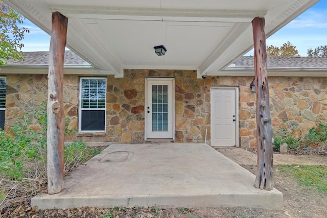 view of exterior entry with a patio