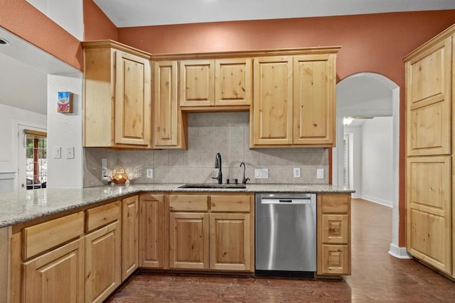 kitchen featuring sink, stainless steel dishwasher, dark hardwood / wood-style floors, tasteful backsplash, and light stone counters