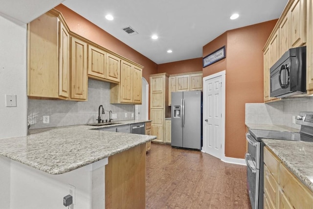 kitchen with kitchen peninsula, stainless steel appliances, dark wood-type flooring, sink, and light brown cabinets