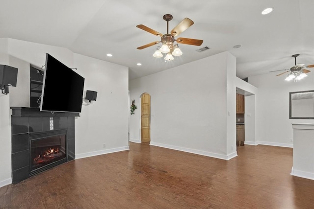 unfurnished living room with ceiling fan, dark hardwood / wood-style flooring, a fireplace, and vaulted ceiling