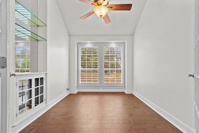 spare room featuring ceiling fan, dark wood-type flooring, and lofted ceiling