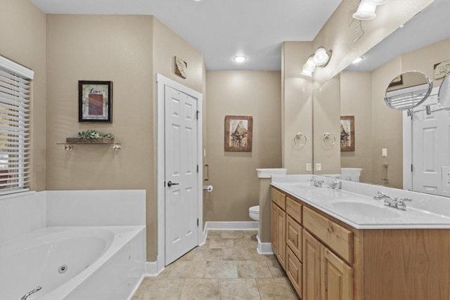 bathroom with vanity, a tub to relax in, and toilet