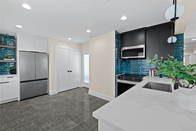 kitchen featuring sink, tasteful backsplash, decorative light fixtures, white cabinets, and appliances with stainless steel finishes