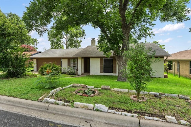 single story home featuring a chimney and a front yard