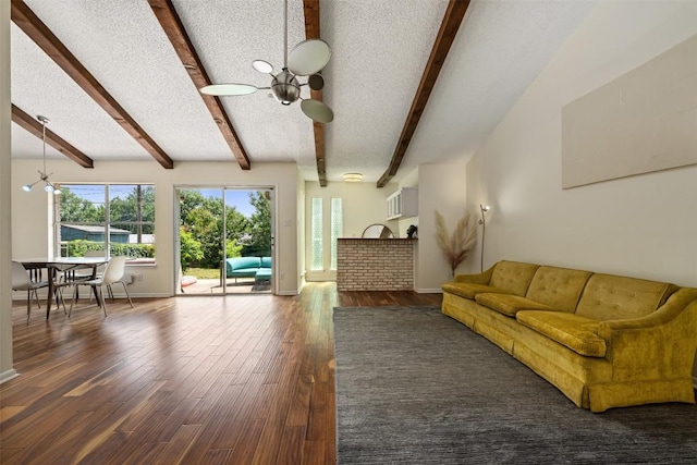 unfurnished living room with vaulted ceiling with beams, dark hardwood / wood-style floors, a textured ceiling, and a notable chandelier