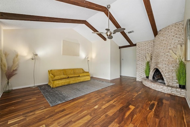 unfurnished living room featuring a fireplace, dark hardwood / wood-style flooring, vaulted ceiling with beams, and ceiling fan