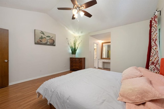 bedroom with connected bathroom, ceiling fan, hardwood / wood-style floors, and lofted ceiling