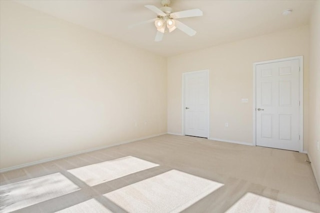 spare room featuring light colored carpet and ceiling fan