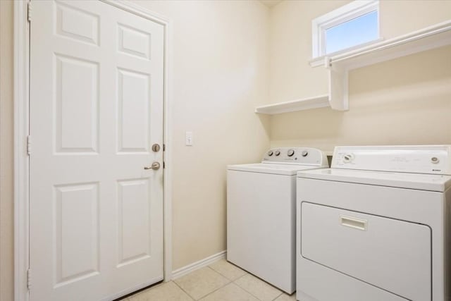 laundry room with light tile patterned floors and washing machine and clothes dryer