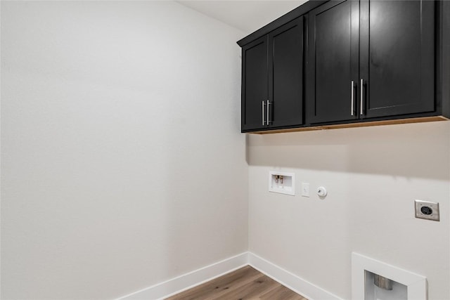 washroom with gas dryer hookup, hardwood / wood-style floors, hookup for a washing machine, cabinets, and hookup for an electric dryer