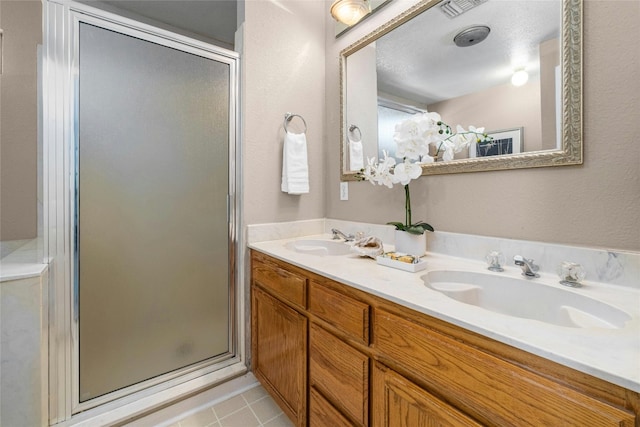 bathroom with vanity, a textured ceiling, and a shower with shower door