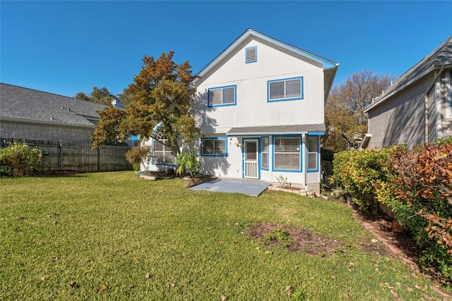 rear view of property featuring a patio and a lawn