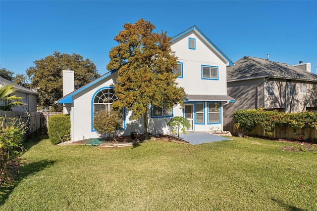 back of property with a yard and a patio area