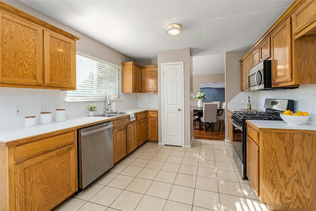 kitchen with sink, light tile patterned floors, and stainless steel appliances