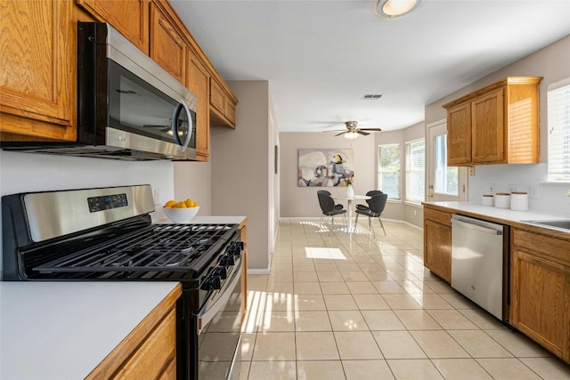 kitchen featuring ceiling fan, sink, light tile patterned floors, and stainless steel appliances