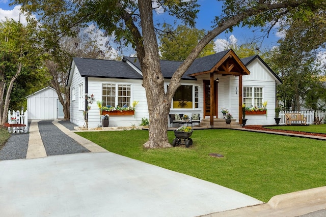 view of front of property with a garage, an outdoor structure, and a front yard