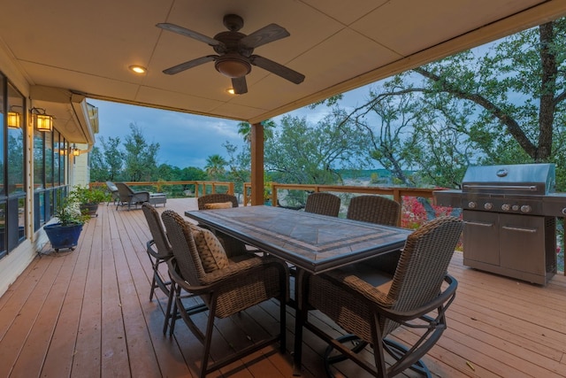 deck at dusk featuring grilling area and ceiling fan