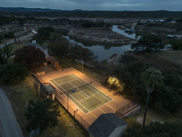 aerial view at dusk featuring a water view