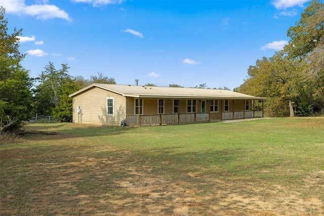 back of property with a yard and a porch