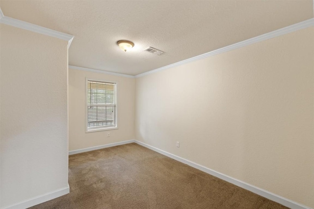 spare room with a textured ceiling, carpet floors, visible vents, baseboards, and ornamental molding