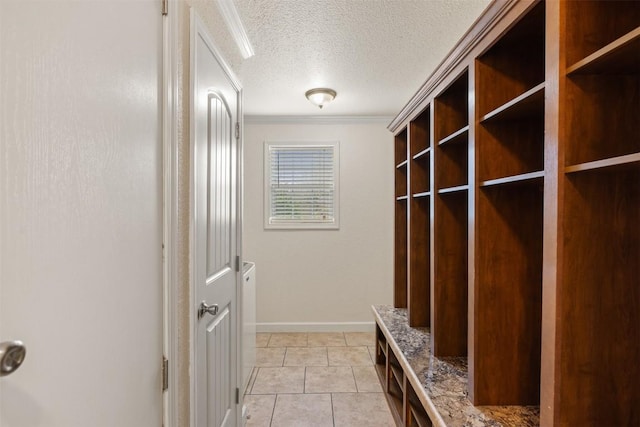 mudroom featuring light tile patterned flooring, crown molding, a textured ceiling, and baseboards