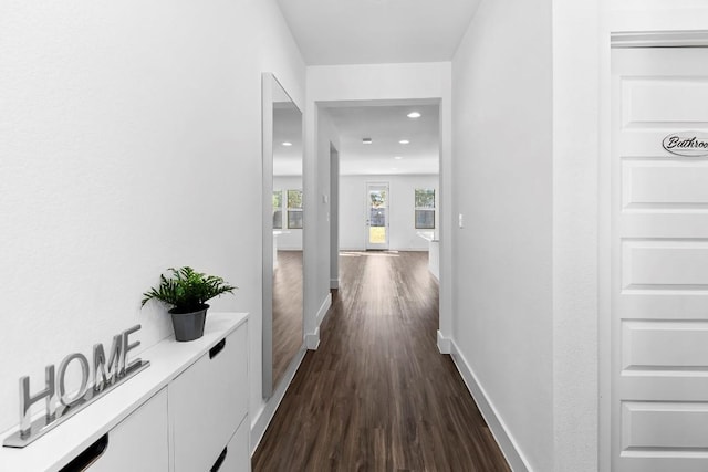 hall with dark wood-style flooring, recessed lighting, and baseboards