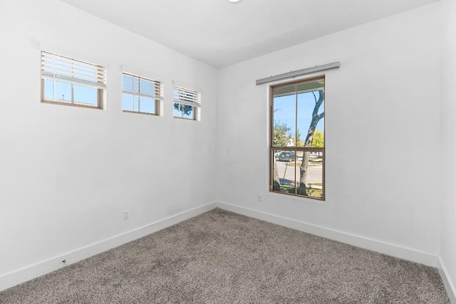 carpeted empty room with baseboards