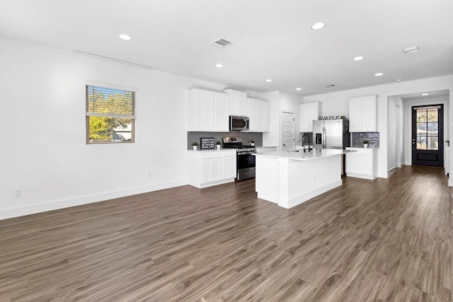 kitchen featuring stainless steel appliances, light countertops, visible vents, white cabinets, and a kitchen island with sink