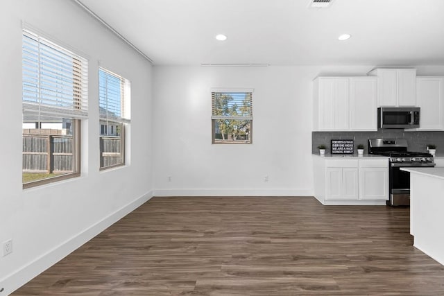 kitchen with stainless steel appliances, white cabinets, light countertops, and decorative backsplash