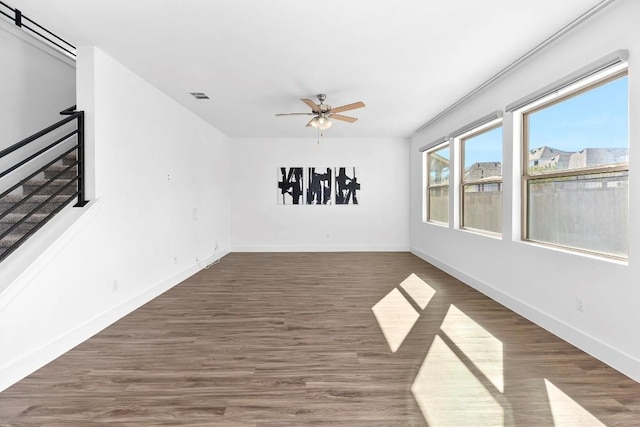 empty room with ceiling fan and dark hardwood / wood-style flooring