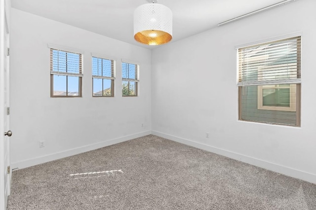 empty room featuring baseboards and carpet flooring