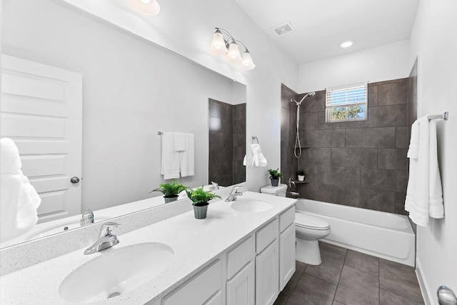 full bathroom with tile patterned flooring, tiled shower / bath combo, toilet, and vanity