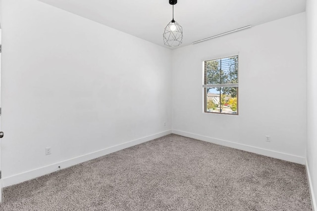 carpeted spare room featuring baseboards