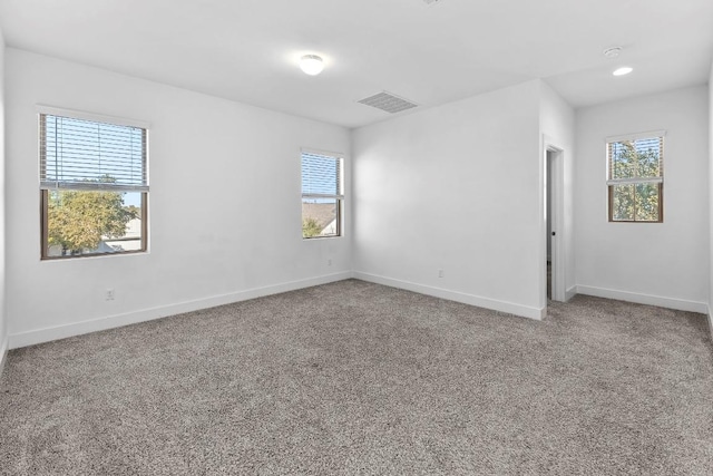 carpeted empty room featuring visible vents and baseboards