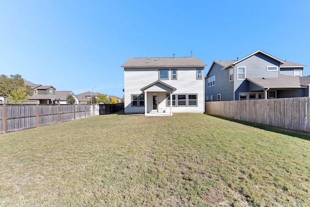 rear view of property with a fenced backyard, a residential view, and a yard