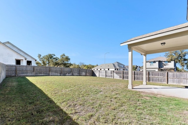 view of yard featuring a residential view, a fenced backyard, and a patio