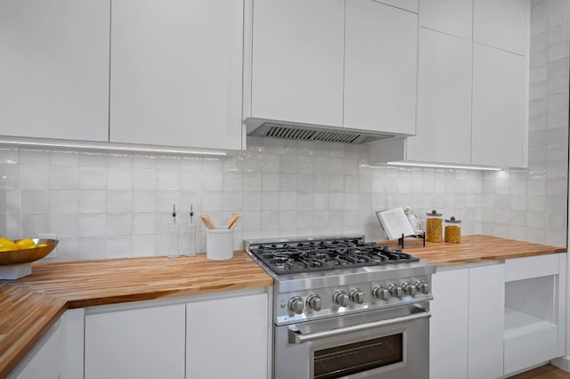 kitchen featuring butcher block countertops, white cabinetry, and high end stainless steel range oven