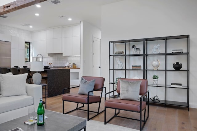 living room featuring beam ceiling and hardwood / wood-style flooring