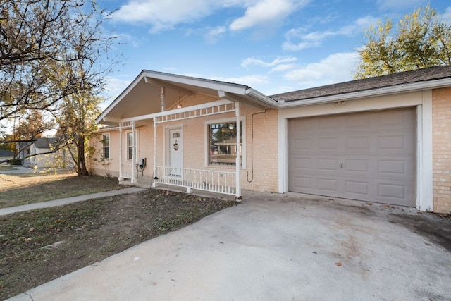 ranch-style home featuring covered porch and a garage