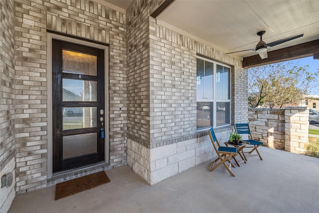 view of exterior entry with a porch and ceiling fan