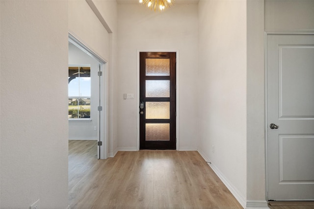 entryway featuring light hardwood / wood-style flooring and a chandelier