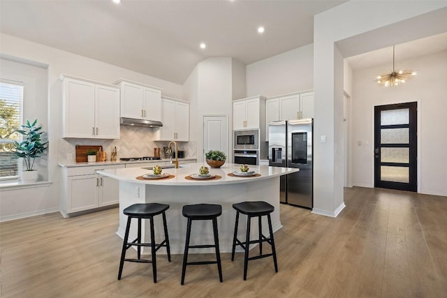 kitchen featuring stainless steel appliances, a kitchen island with sink, and white cabinetry