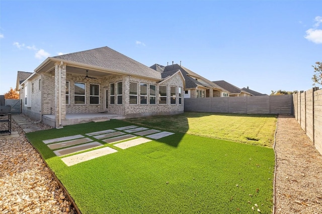 back of property with a lawn and a patio area