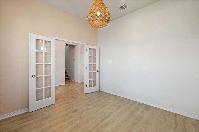 unfurnished room with light hardwood / wood-style floors and french doors