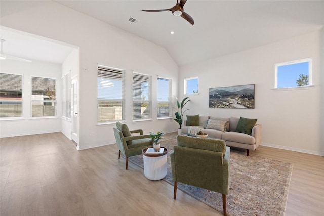 living room featuring ceiling fan, vaulted ceiling, and light hardwood / wood-style flooring